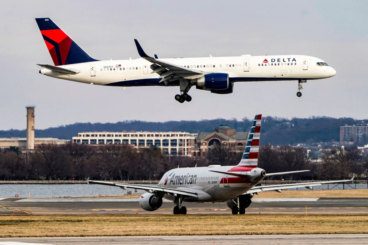 An American Airlines plane taxis as a Delta Air Lines aircraft lands at Reagan National Airport in Arlington, Va., on Jan. 24, 2022. (Joshua Roberts/Reuters)