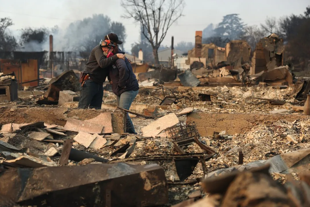 Khaled Fouad (L) and Mimi Laine (R) embrace as they inspect a family member's property that was destroyed by Eaton Fire in Altadena, Calif., on Jan. 9, 2025. (Justin Sullivan/Getty Images)