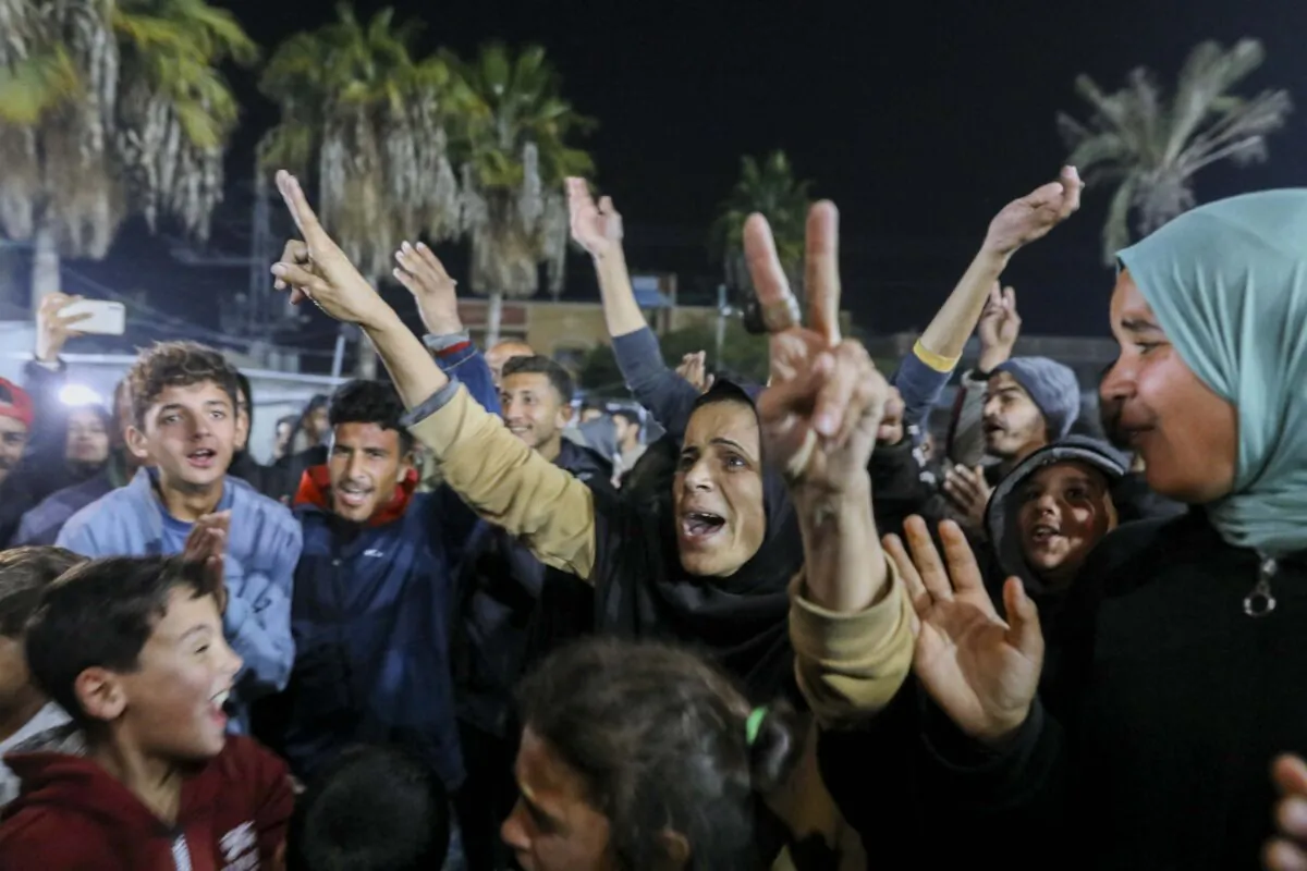 People celebrate along a street at Deir el-Balah in the central Gaza Strip, on January 15, 2025, (Youssef Alzanoun /Middle East Images/AFP via Getty Images)
