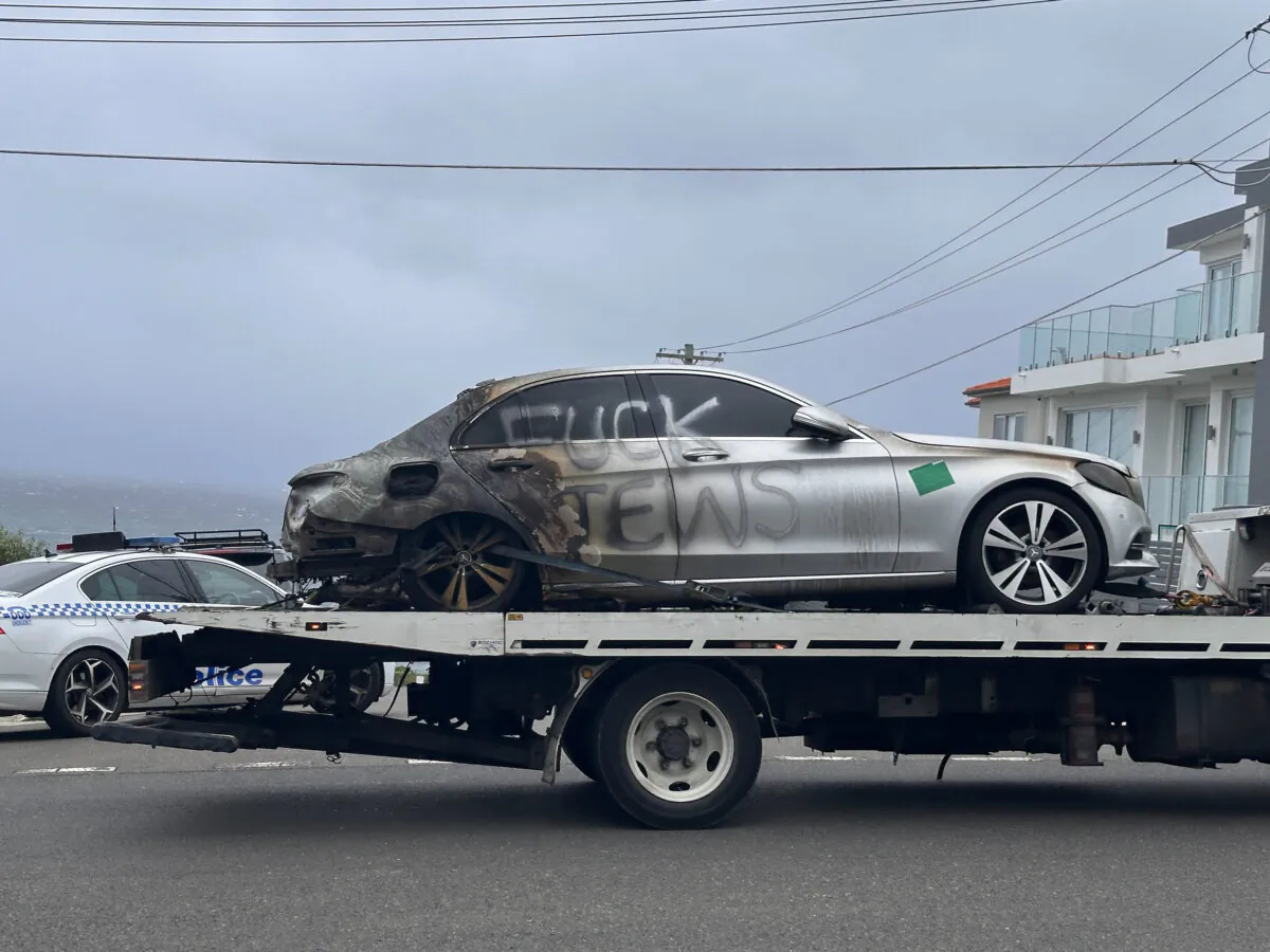A burnt out car with anti-semitic graffiti is towed away in Dover Heights, Sydney, Australia on Jan. 17, 2025. (AAP Image/Neve Brissendeni)