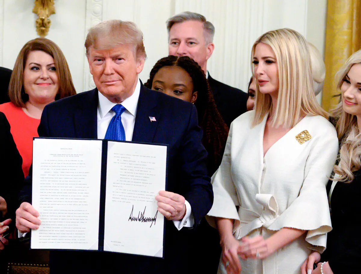 President Donald Trump holds up an executive order on combating human trafficking next to Ivanka Trump (R) in the East Room of the White House on Jan. 31, 2020. (Andrew Caballero-Reynolds/AFP via Getty Images)