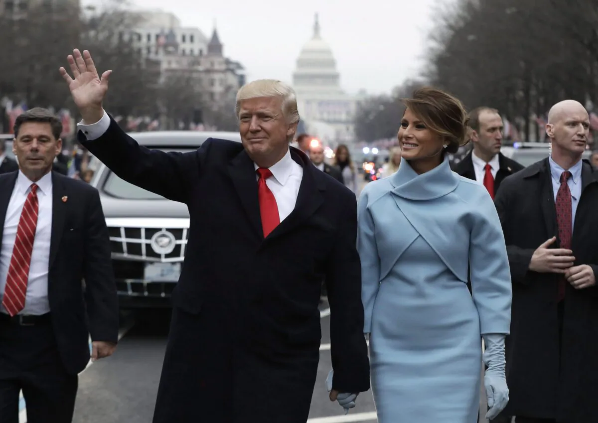 U.S. President Donald Trump waves as he walks with first lady Melania Trump during the inauguration parade on Pennsylvania Avenue in Washington on Jan. 20, 2016. (The Canadian Press/AP-Evan Vucci)