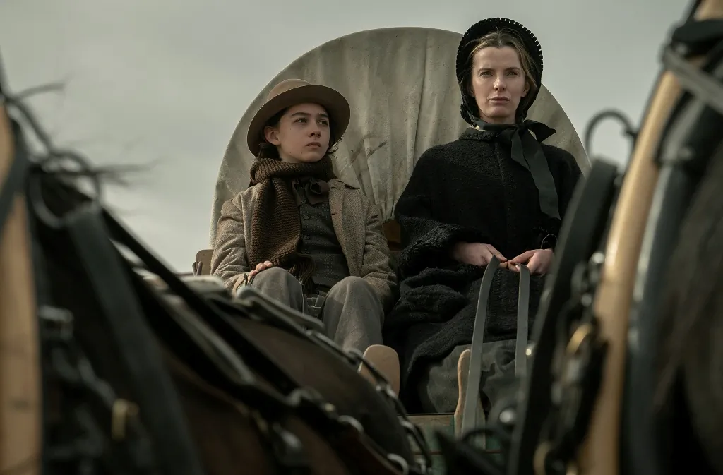 Devin Rowell (Preston Mota) and Sara Holloway/Rowell (Betty Gilpin) are traveling West, in "American Primeval." (Netflix)