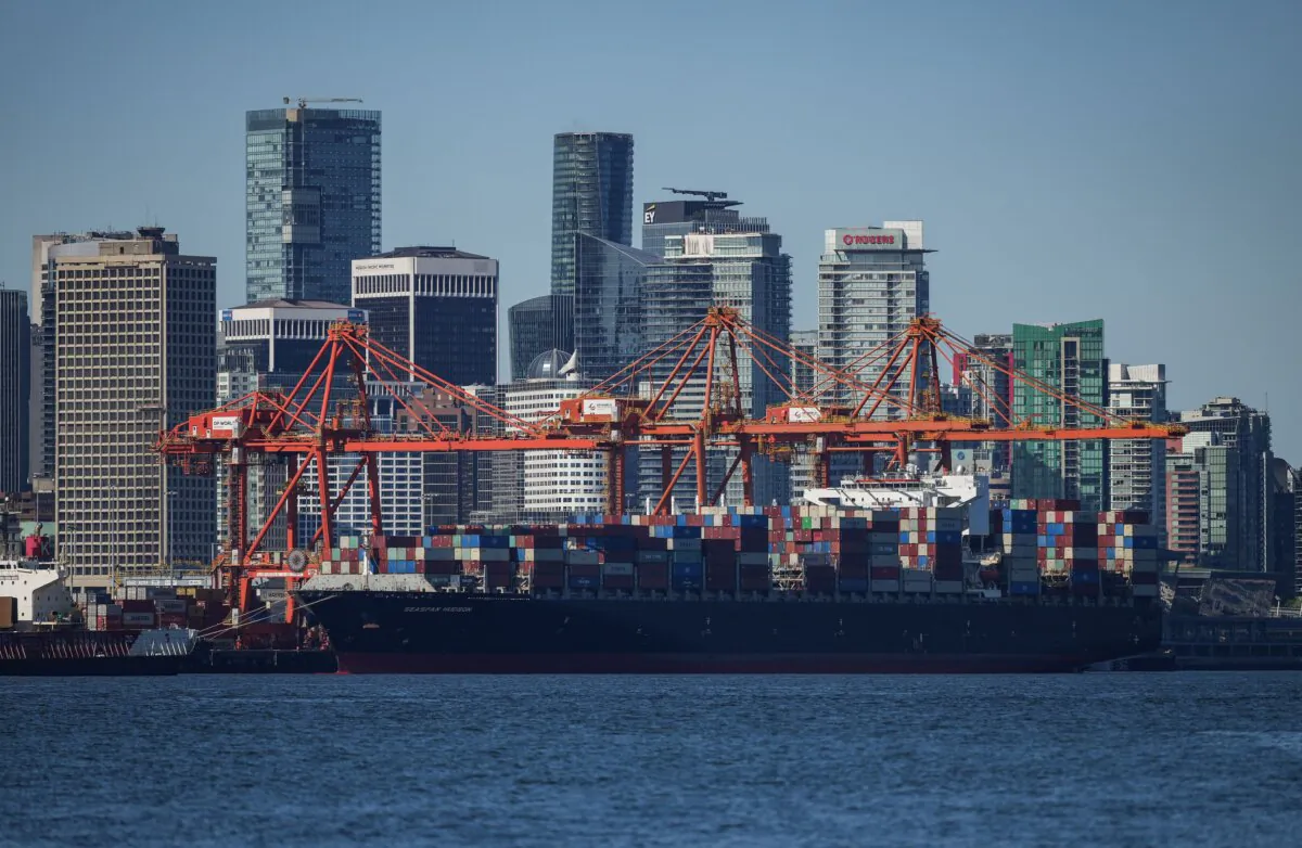 A container ship docked under gantry cranes at port and the downtown Vancouver skyline are seen in a file photo. (The Canadian Press/Darryl Dyck)