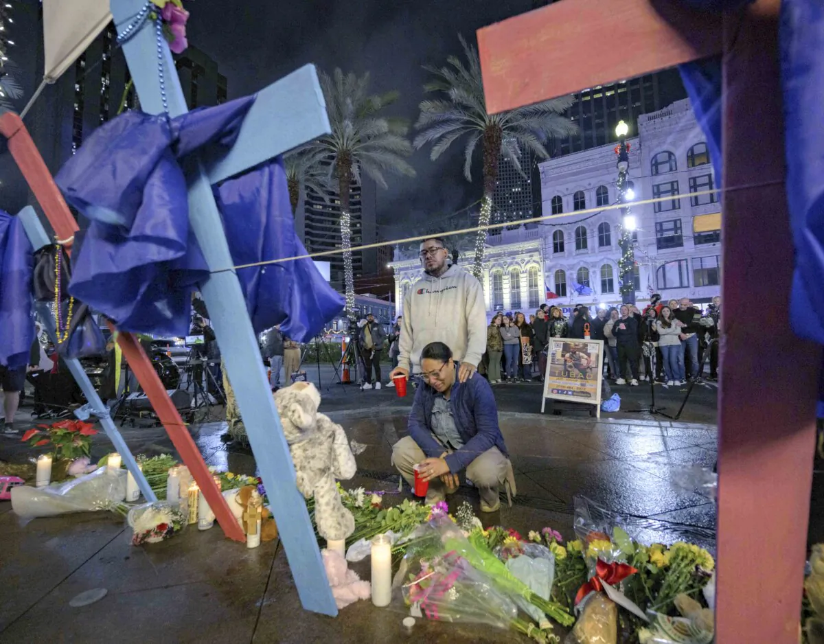 People visit a memorial to victims of the New Year's Eve deadly truck attack near the intersection of Canal and Bourbon streets in New Orleans, on Jan. 4, 2025. (AP Photo/Matthew Hinton)