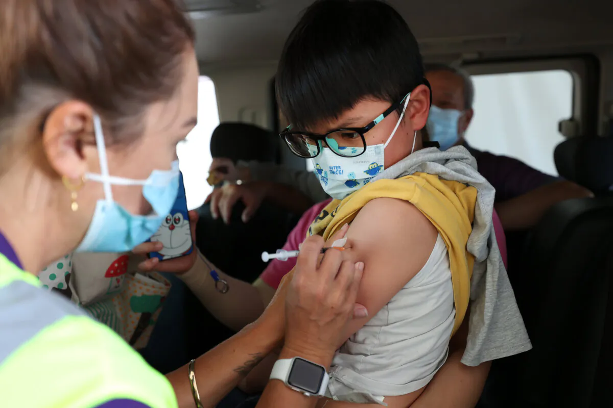 A boy is vaccinated at the drive-through vaccination centre at North Shore Events Centre in Auckland, New Zealand on Jan. 17, 2022. (Fiona Goodall/Getty Images)