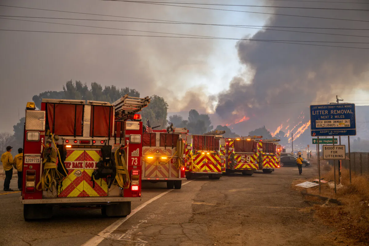 Firefighters station at the base of Lake Hughes road as the Hughes Fire burns in the distance in Castaic, Calif., on January 22, 2025. The wildfire is prompting mandatory evacuations just over two weeks after the Eaton and Palisades Fires caused widespread destruction across Los Angeles County. (Brandon Bell/Getty Images)