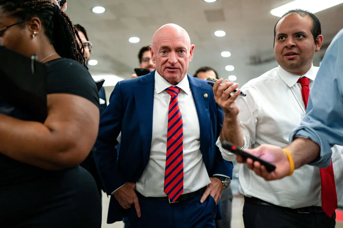 Sen. Mark Kelly (D-Ariz.) speaks with reporters while waiting to catch the Senate subway to the Hart Senate Office Building from the U.S. Capitol in Washington on July 25, 2024. (Kent Nishimura/Getty Images)