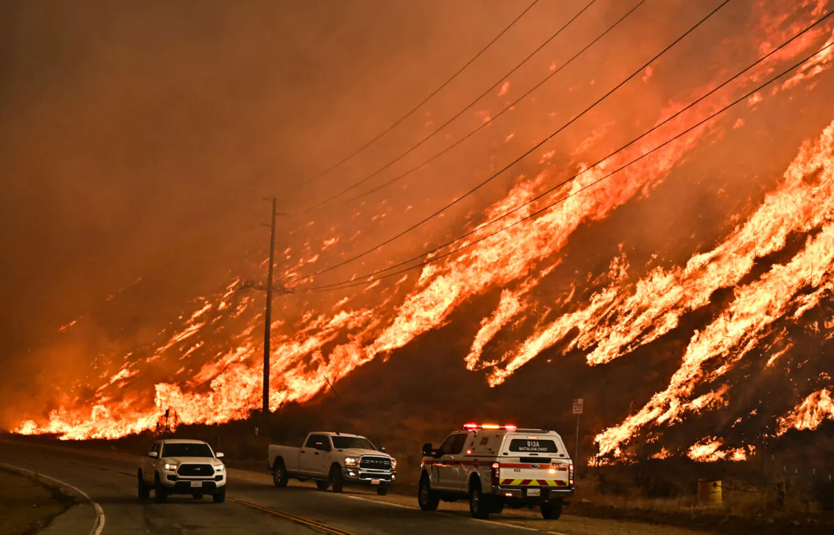 Emergency vehicles are on the side of the road as flames from the Hughes Fire race up the hill in Castaic in Los Angeles County, on Jan. 22, 2025. (Frederic J. Brown/AFP via Getty Images)