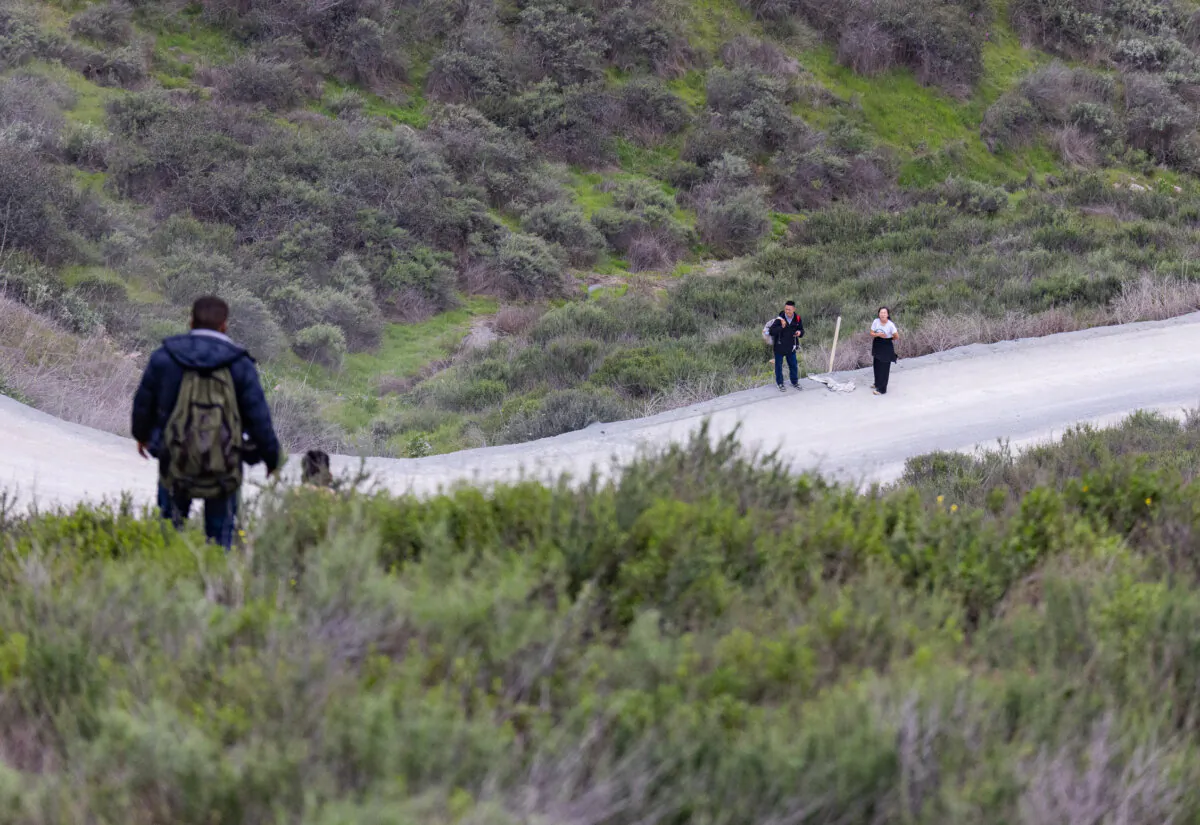 Migrants walk toward a Border Patrol checkpoint from the "Otay Gap" in Otay Mesa, Calif., on Feb. 29, 2024. (John Fredricks/The Epoch Times)