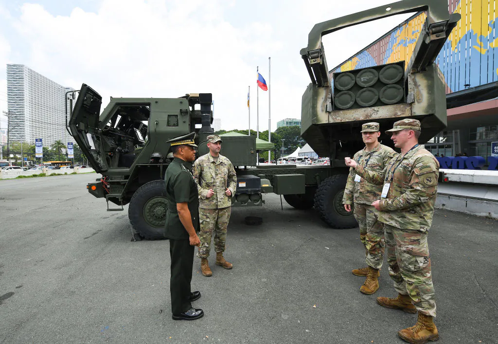 Armed Forces of the Philippines Chief of Staff Gen. Romeo Brawner (L) talks to U.S. soldiers as they stand to a High Mobility Artillery Rocket System (HIMARS), displayed at the Asian Defense and Security Exhibition (ADAS) in Manila on Sept. 25, 2024. (Ted Aljibe/AFP/Getty Images)