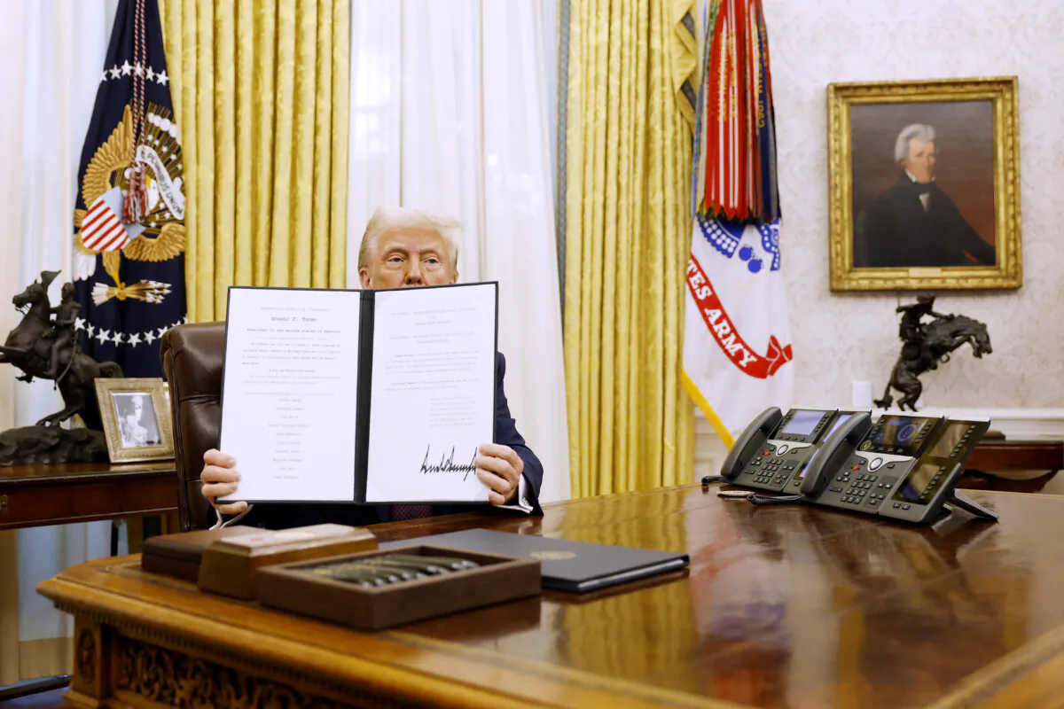 President Donald Trump holds up a signed executive order in the Oval Office on Jan. 23, 2025. (Anna Moneymaker/Getty Images)