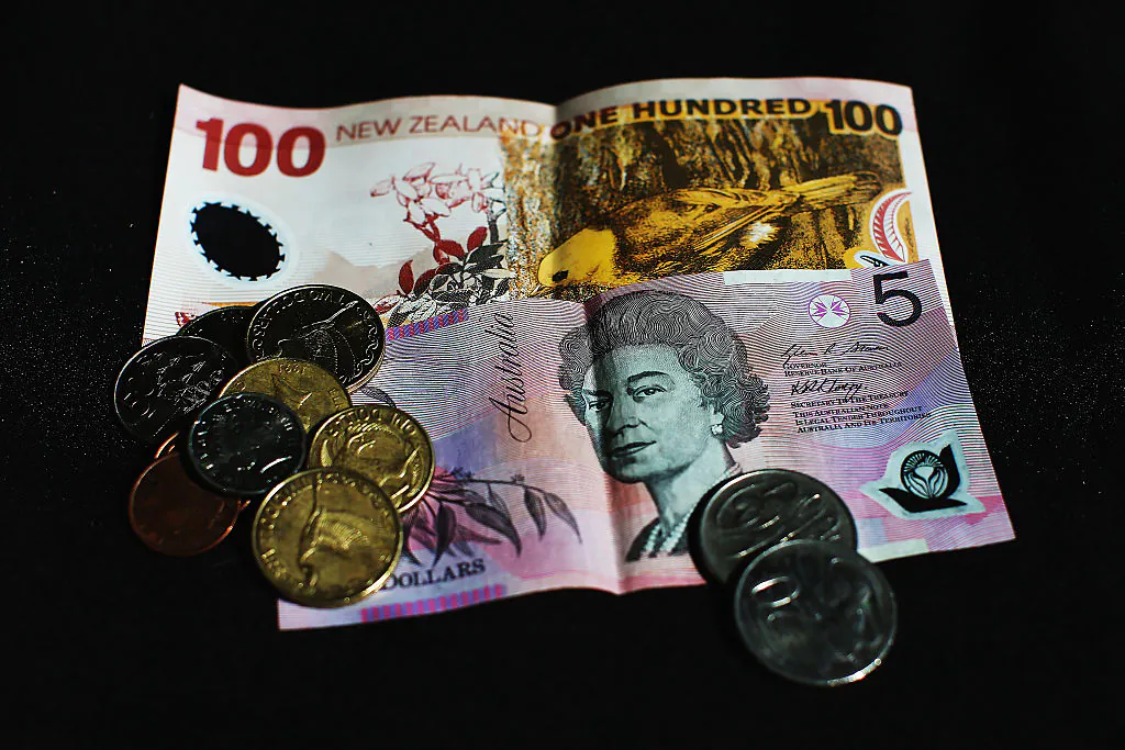 A New Zealand one-hundred dollar banknote, an Australian five dollar banknote and New Zealand coins are arranged for a photo in Auckland, New Zealand on April 7, 2015. (Hannah Peters/Getty Images)
