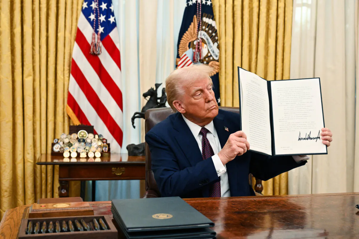 US President Donald Trump holds up an executive order he just signed to strenghten American leadership in digital financial technology, in the Oval Office of the White House in Washington, DC, on January 23, 2025. (Photo by ROBERTO SCHMIDT / AFP) (Photo by ROBERTO SCHMIDT/AFP via Getty Images)