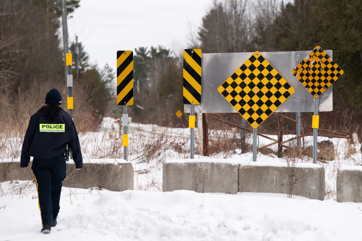 An RCMP officer checks the border between Quebec and New York State on Roxham Road in St. Bernard-de-Lacolle, Que. on Jan.15, 2025.  (The Canadian Press/Christinne Muschi) 