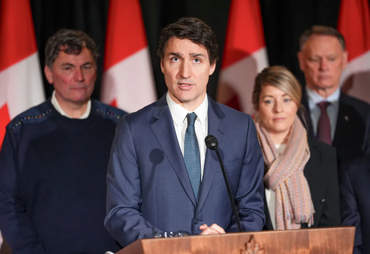 Canadian Prime Minister Justin Trudeau is joined by Minister of Finance Dominic LeBlanc, (back left to right), Minister of Foreign Affairs Melanie Joly, Minister of Public Safety David McGuinty, as he holds a press conference during a Cabinet retreat at Chateau Montebello in Montebello, Canada, on Jan. 21, 2025. (Sean Kilpatrick/The Canadian Press via AP)