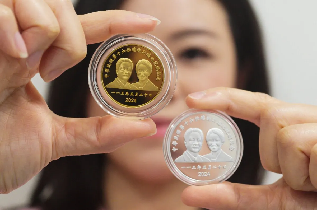 A woman displays a one ounce commemorative gold coin and one ounce silver coin with Taiwan’s newly elected President Lai Ching-te and Vice President Hsiao Bi-khim portraits  in Taipei on March 20, 2024. (Sam Yeh / AFP)