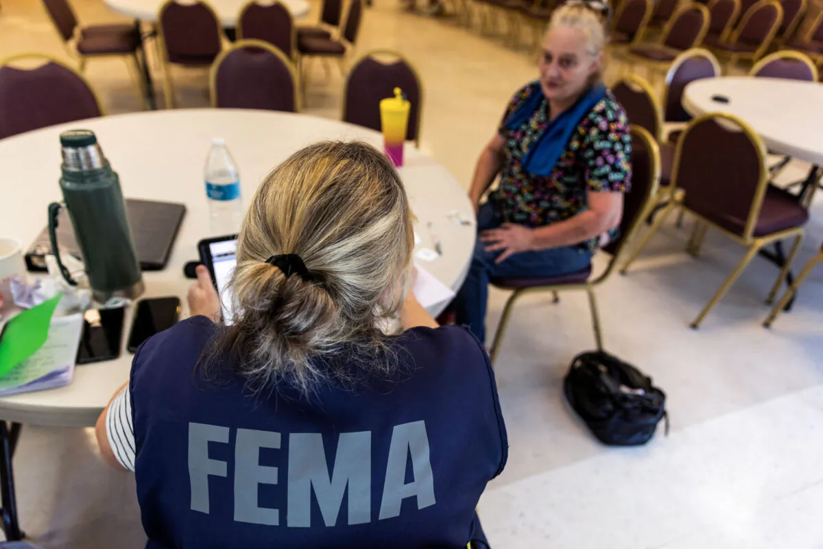 A FEMA worker attends a claim by a local resident after being affected by floods following the passing of Hurricane Helene in Marion, N.C., on Oct. 5, 2024. (Eduardo Munoz/Reuters)