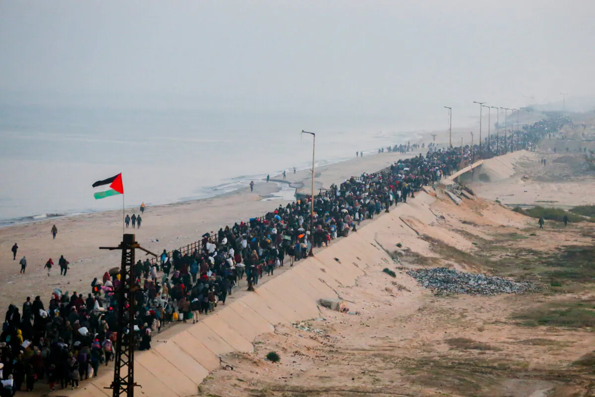 Redem walk along Gaza's Al-Rashid coastal street to cross the Netzarim Corridor from the southern Gaza Strip to the north on Jan. 27, 2025. (Youssef Alzanoun/Middle East Images/AFP via Getty Images)