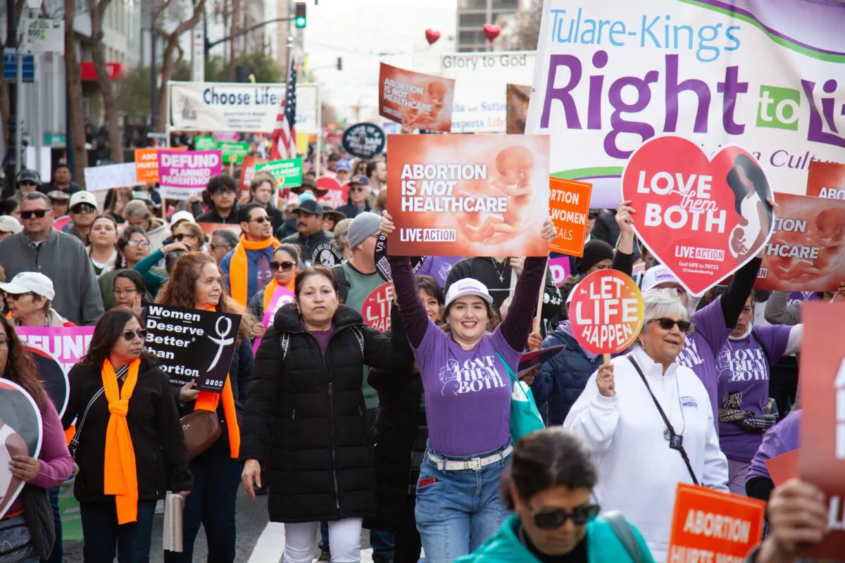 People holding signs during 21st annual Walk For Life in San Francisco, Calif., on Jan. 25, 2025. (Lear Zhou/The Epoch Times)