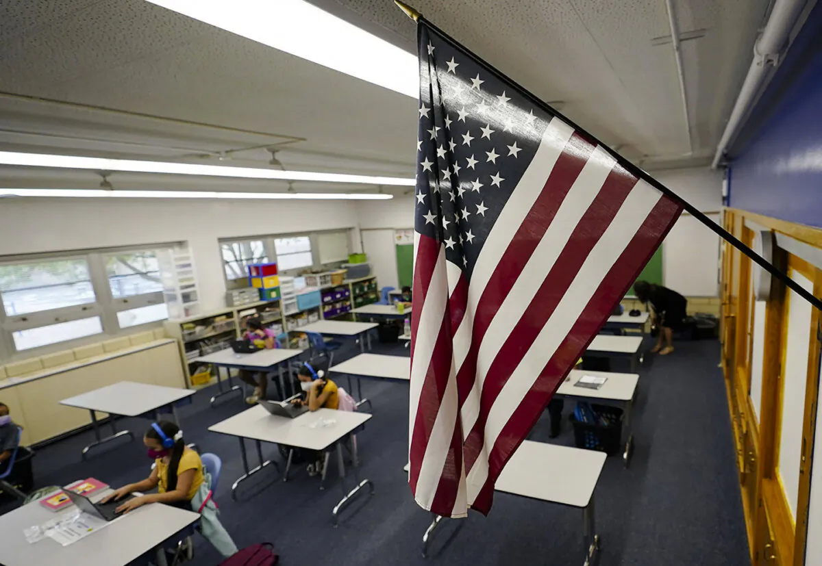 A U.S. flag hangs in a classroom as students work on laptops in Newlon Elementary School in Denver, in a file photo. (David Zalubowski/AP Photo)