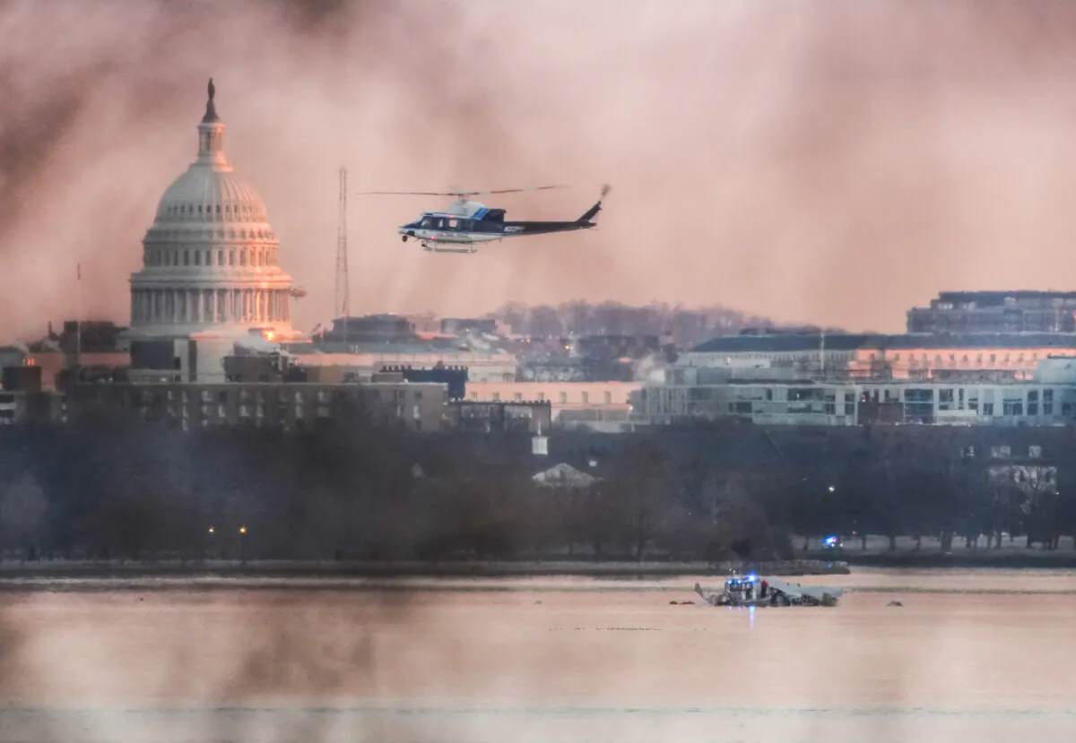A helicopter flies near the crash site of the American Airlines plane on the Potomac River after the plane crashed on approach to Ronald Reagan Washington National Airport in Arlington, Va., on Jan. 30, 2025. (Andrew Harnik/Getty Images)