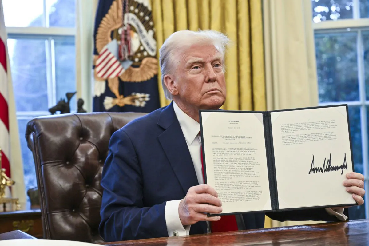 US President Donald Trump shows an executive order he signed in the Oval Office of the White House in Washington, on Jan. 30, 2025. (Roberto Schmidt/AFP via Getty Images)