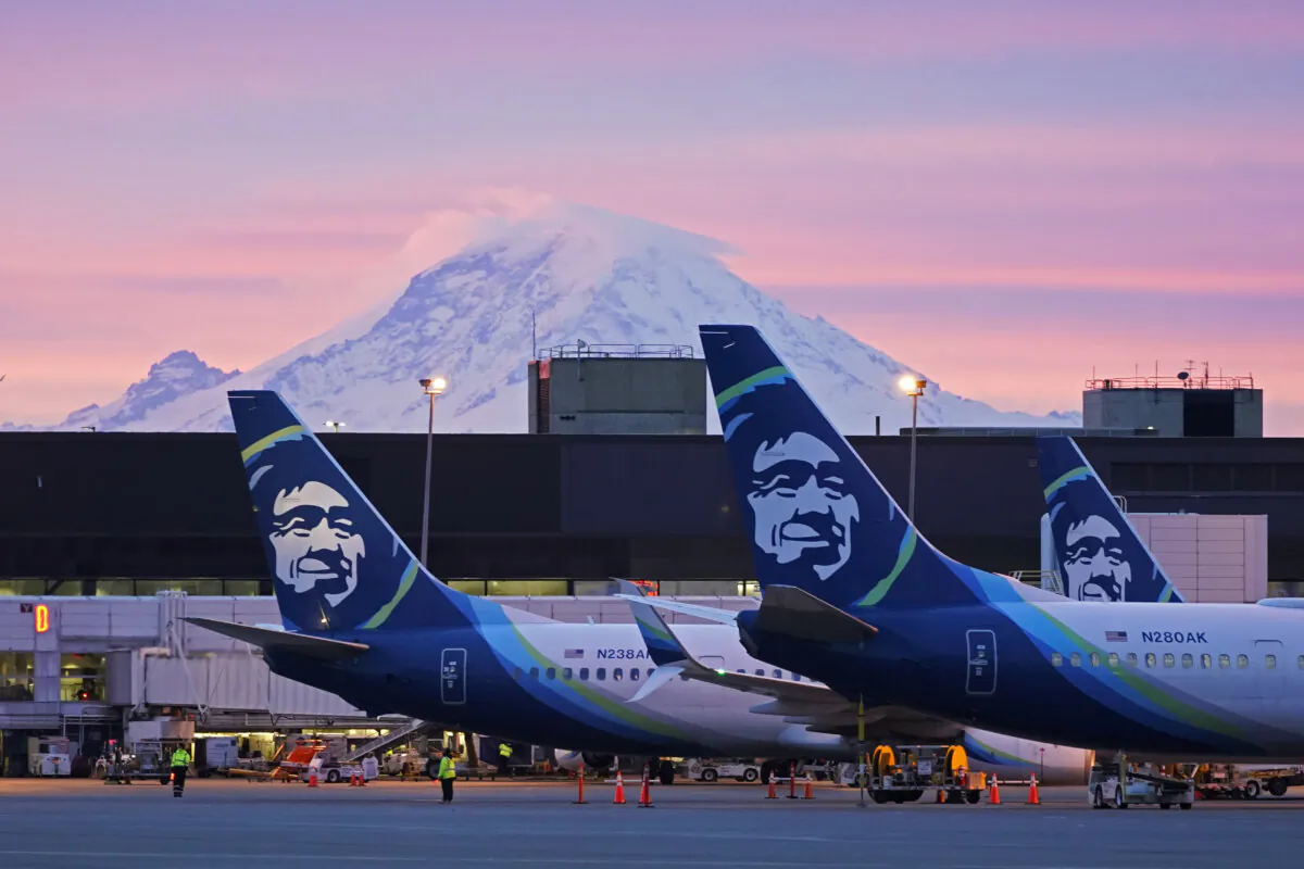 Alaska Airlines planes parked at gates with Mount Rainier in the background at sunrise at Seattle-Tacoma International Airport in Seattle on March 1, 2021. (Ted S. Warren/AP Photo)