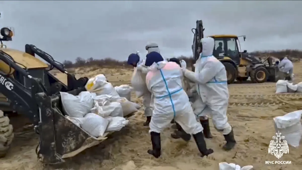 Rescuers and volunteers work to clean up tons of fuel oil that spilled out of two storm-stricken tankers more than two weeks ago in the Kerch Strait, in Russia's southern Krasnodar region, on Jan. 4, 2025. (Russian Emergency Ministry Press Service via AP)