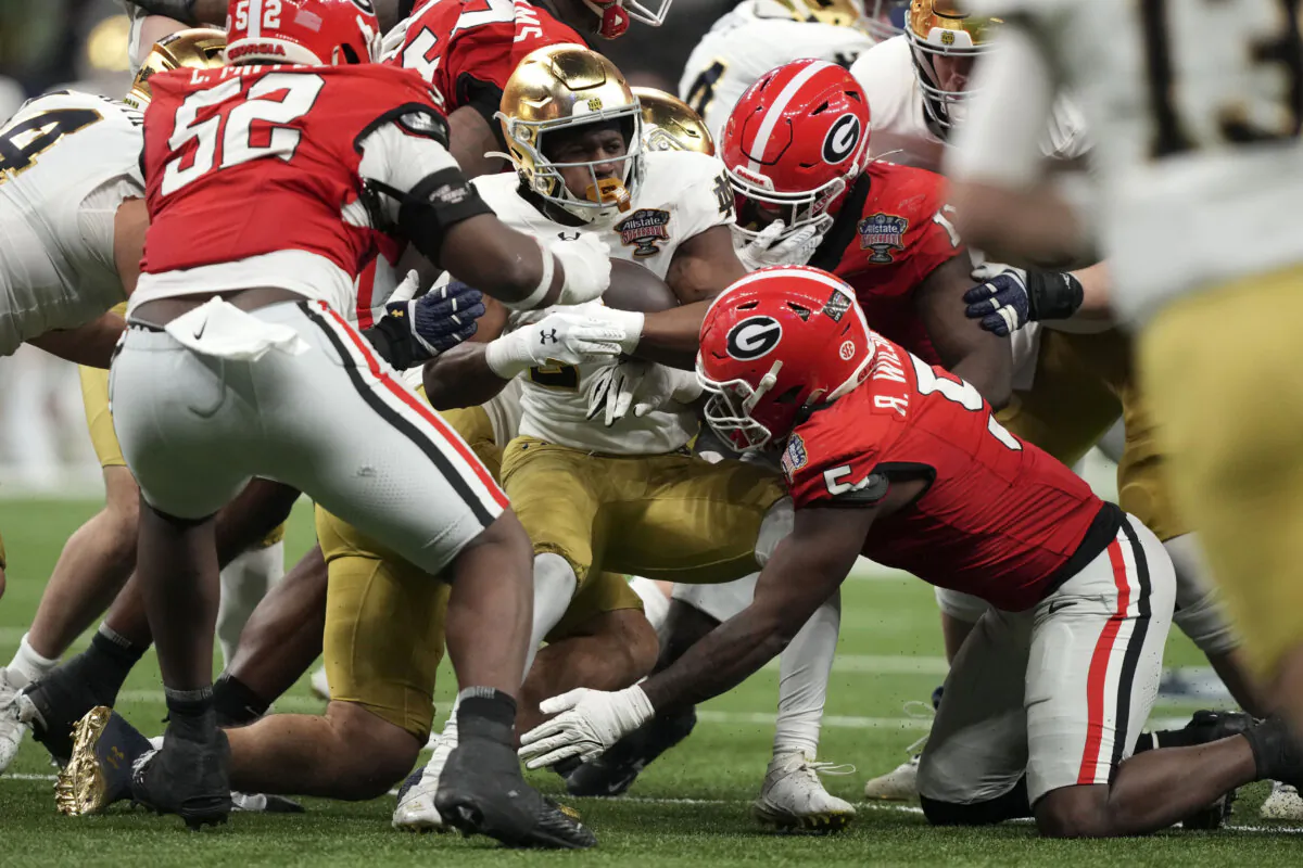 Notre Dame running back Jadarian Price (C) is tackled by Georgia linebacker Raylen Wilson during a college football playoff game, in New Orleans on Jan. 2, 2025. (Gerald Herbert/AP Photo)