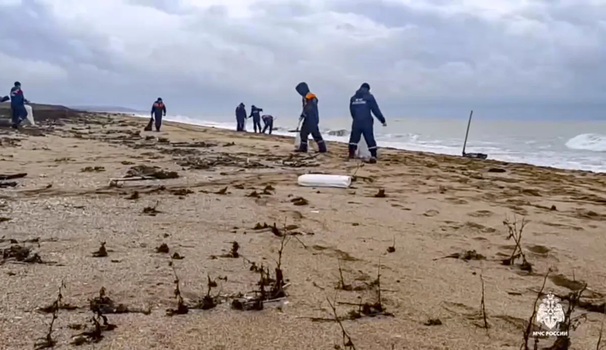 Rescuers work to clean up tons of fuel oil that spilled out of two storm-stricken tankers more than two weeks ago in the Kerch Strait, in Russia's southern Krasnodar region, in a photo released on Jan. 4, 2025. (Russian Emergency Ministry Press Service via AP)