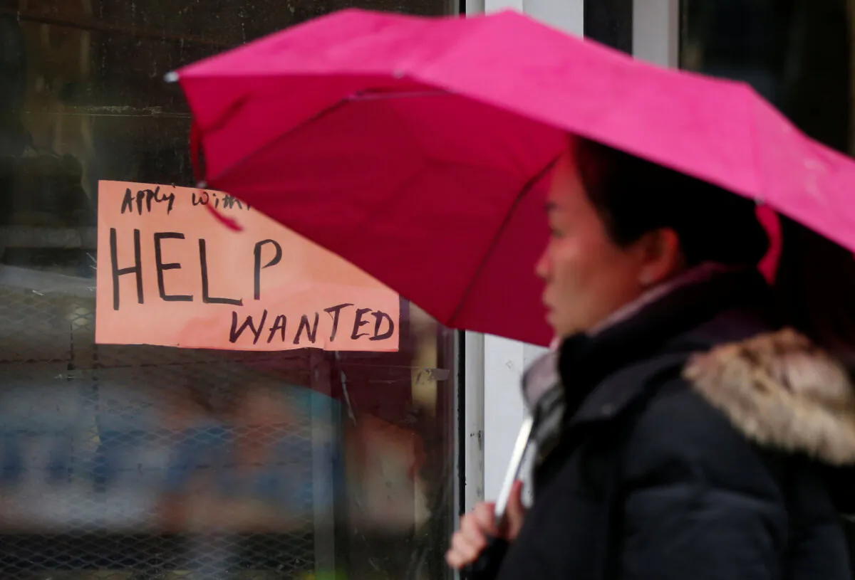 A woman walks past a "Help wanted" sign at a retail store in Ottawa, on Nov. 2, 2017. (ReutersChris Wattie)