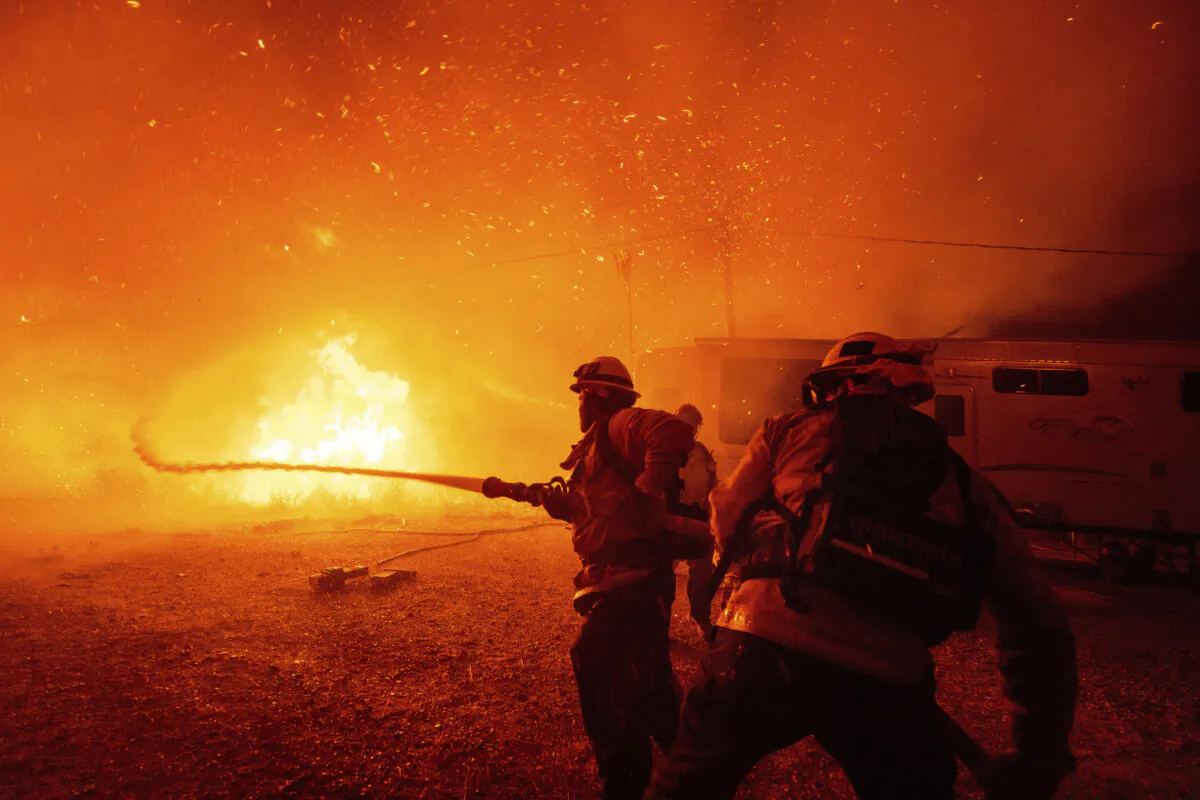 Firefighters spray water on the Hughes Fire in Castaic, Calif., on Jan. 22, 2025. (Ethan Swope/AP Photo)