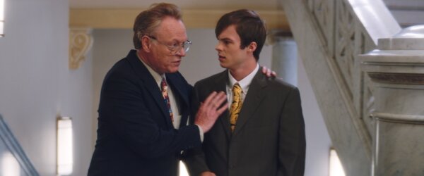 older man and young man in dark suits in Brave the Dark