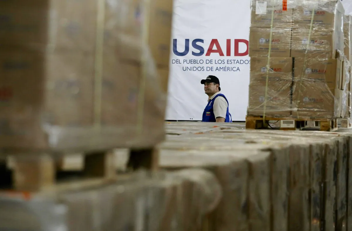A man walks past boxes of USAID humanitarian aid at a warehouse at the Tienditas International Bridge on the outskirts of Cucuta, Colombia, Feb. 21, 2019, on the border with Venezuela. (AP Photo/Fernando Vergara)
