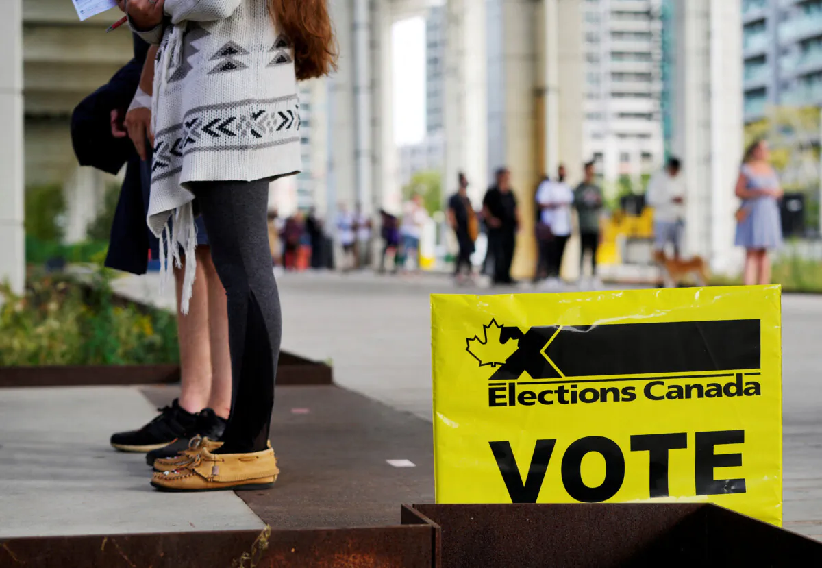 People line up outside a polling station in Toronto to vote in Canada's federal election on Sept. 20, 2021. (Mark Blinch/Reuters)