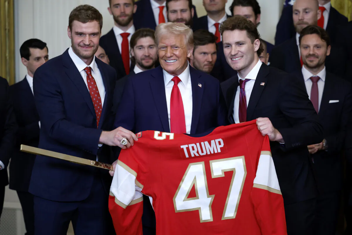 President Donald Trump receives a jersey and a hockey stick from Florida Panthers Matthew Tkachuk (R) and Aleksander Barkov as Trump honored the 2024 Stanley Cup champions Florida Panthers in the East Room of the White House on Feb. 3, 2025. (Kevin Dietsch/Getty Images)