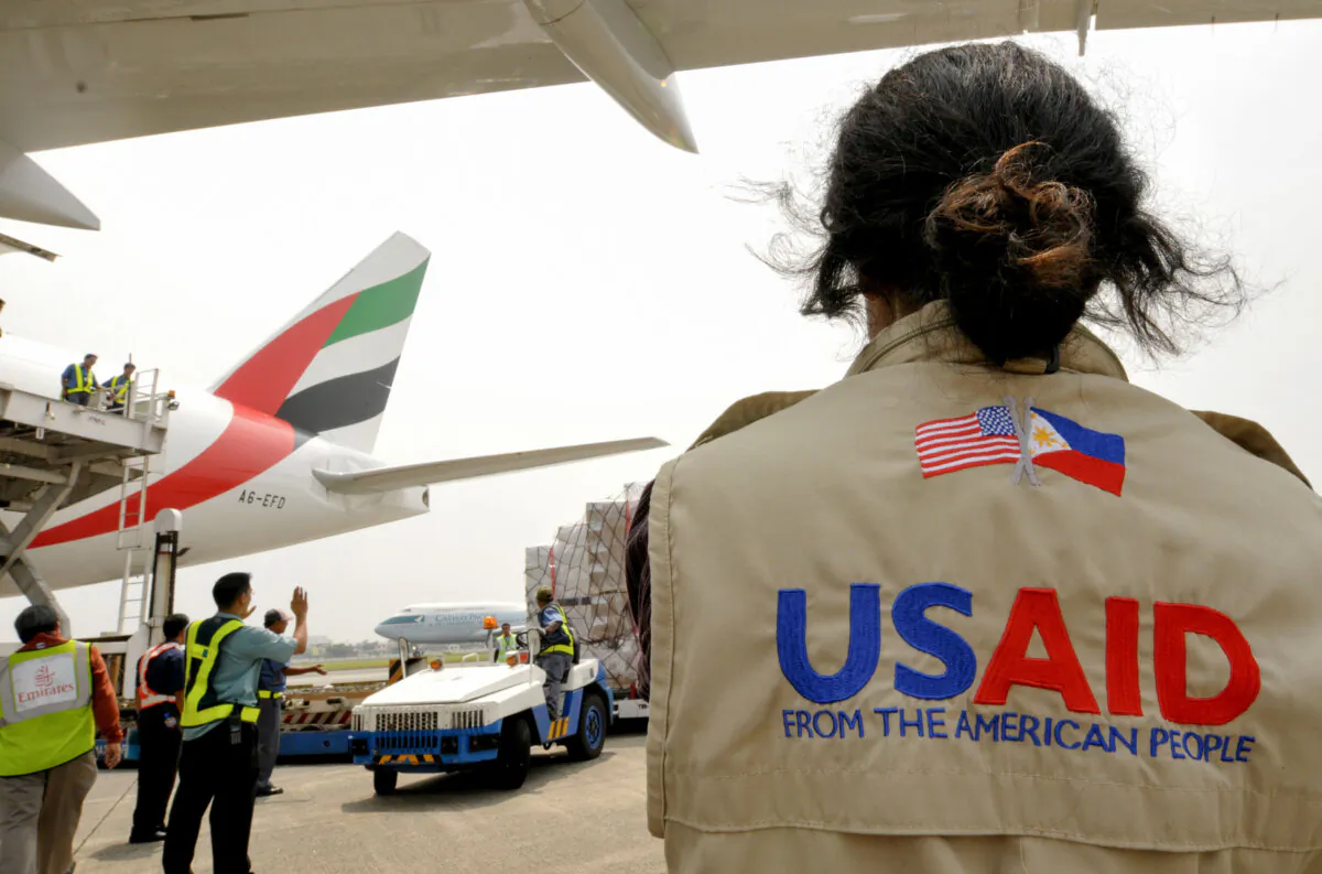 A USAID worker watches as relief supplies are unloaded at Manila's international airport on Oct. 13, 2009. (Jay Directo/AFP via Getty Images)