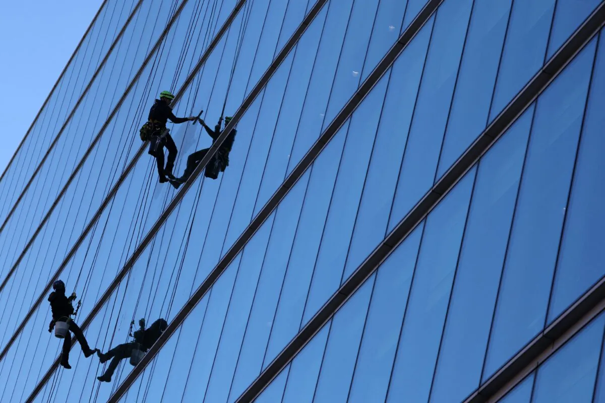 Window cleaners clean the glass windows of a commercial high-rise office building in London, England on Feb. 6, 2023. (Adrian Dennis/AFP via Getty Images)