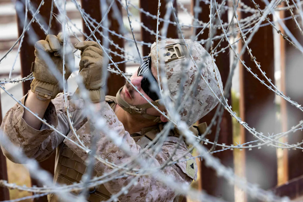 A U.S. Marine with 1st Combat Engineer Battalion, 1st Marine Division, secures concertina wire together along the southern border wall near San Ysidro, Calif., Jan. 27, 2025. U.S. Northern Command is working with the Department of Homeland Security to place physical barriers to curtail illegal border crossings. (Lance Cpl. Caleb Goodwin/U.S. Marine Corps)