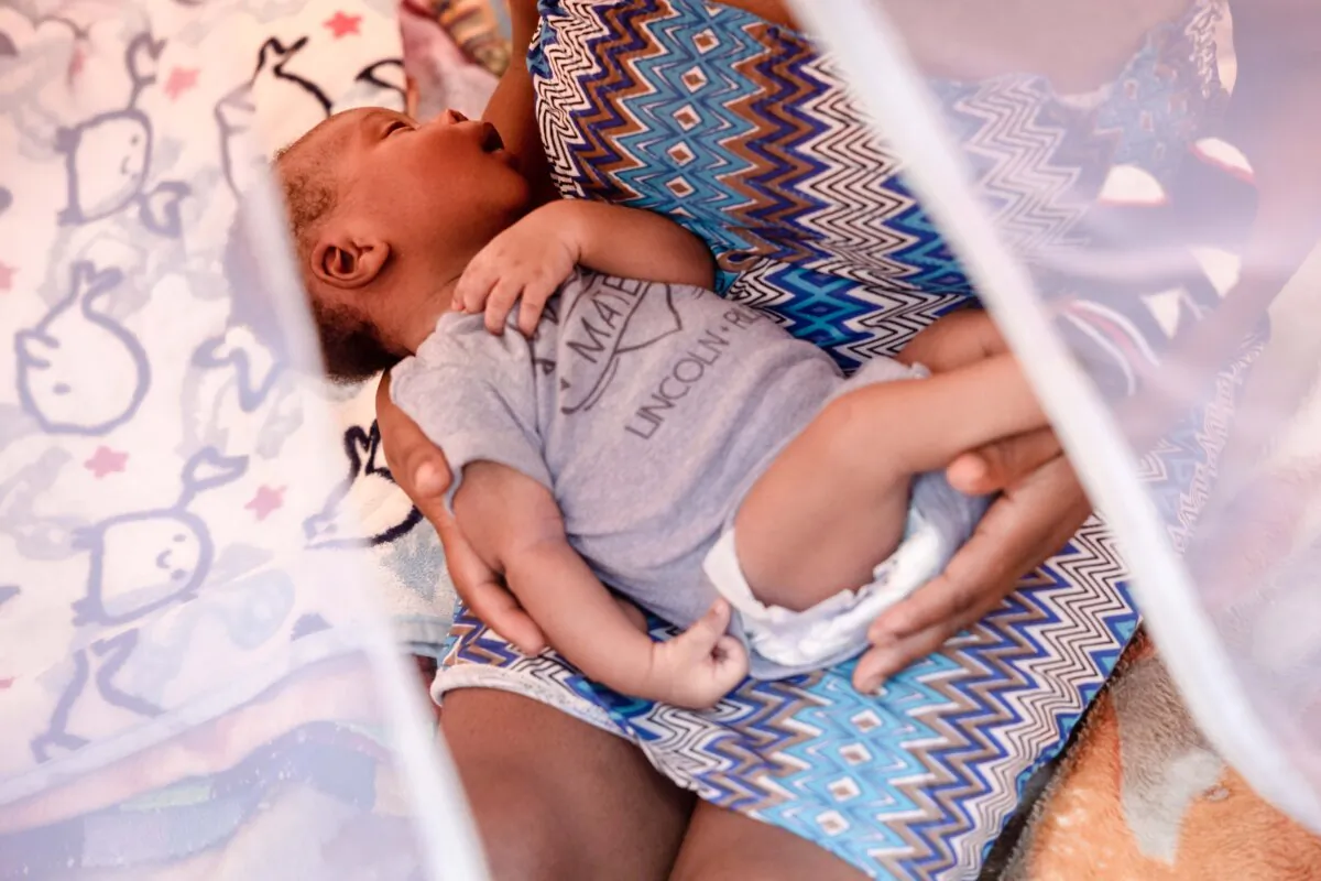 A Haitian mother holds her newborn inside a tent in the large migrant camp near an international bridge at the U.S.-Mexico border in Del Rio, Texas, on Sept. 21, 2021. (John Moore/Getty Images)