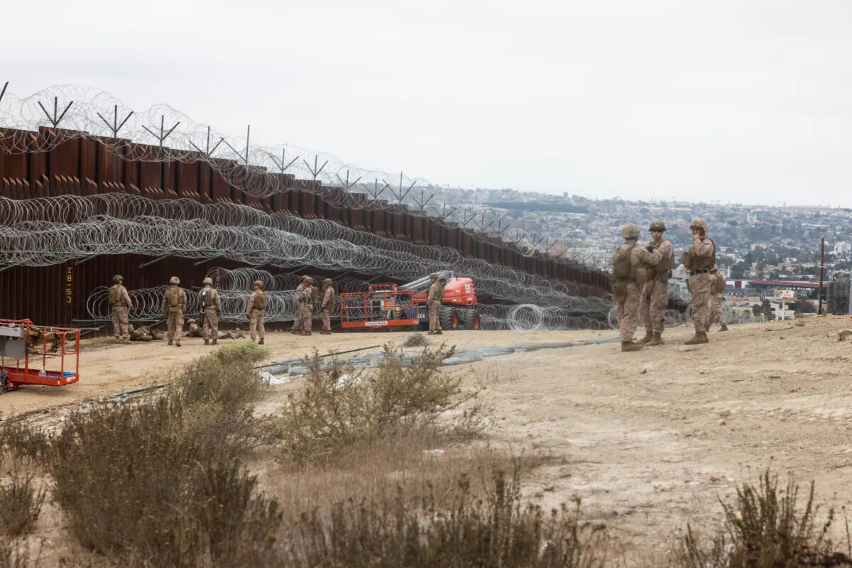 U.S. Marines from 1st Combat Engineer Battalion, 1st Marine Division, deploy concertina wire along the southern border wall near San Ysidro, Calif., on Feb. 4, 2025. (U.S. Marine Corps photo by Lance Cpl. Caleb Goodwin)