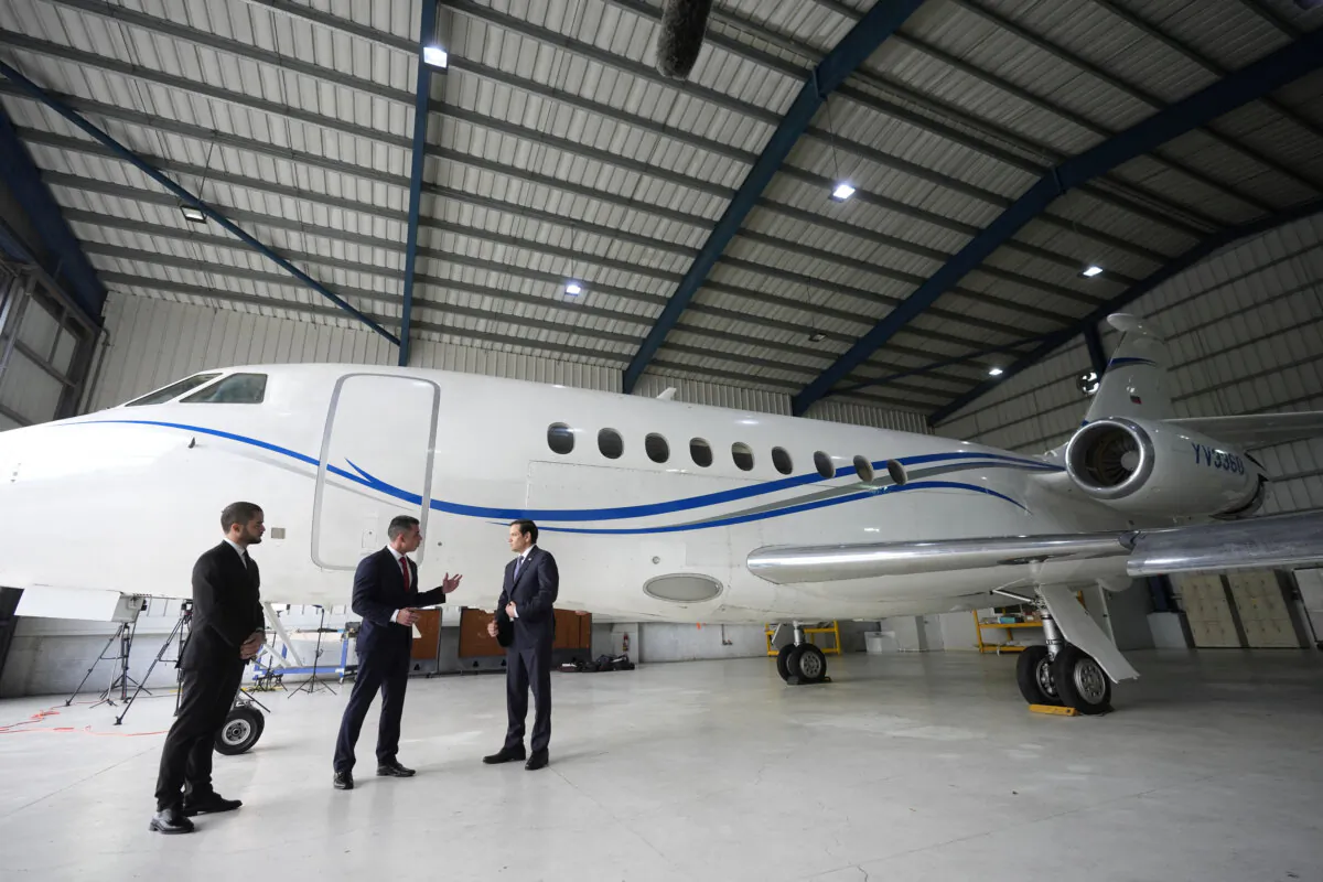U.S. Secretary of State Marco Rubio listens to Edwin F. Lopez, the attache for DHS Homeland Security Investigations, next to the Venezuelan government airplane that Rubio announced is being seized by the United States, during a news conference at La Isabela International Airport in Santo Domingo, Dominican Republic, on Feb. 6, 2025. (Mark Schiefelbein/Pool via Reuters)