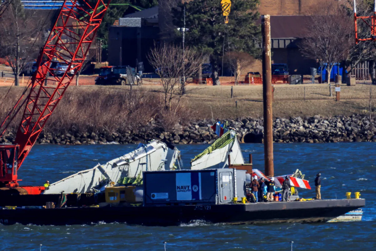 A crane retrieves part of the wreckage from the Potomac River, in the aftermath of the collision of American Airlines flight 5342 and a Black Hawk helicopter that crashed into the river near the Ronald Reagan Washington National Airport, in Arlington, Va., on Feb. 4, 2025. (Eduardo Munoz/Reuters)
