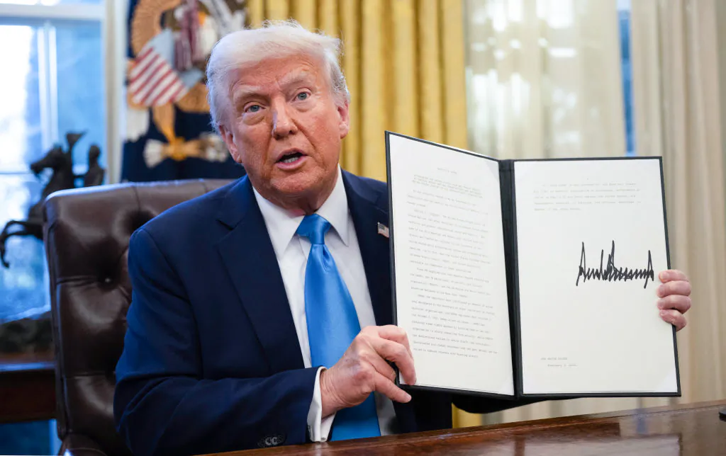 President Donald Trump shows an executive order withdrawing the United States from a number of U.N. bodies in the Oval Office on Feb. 4, 2025. (Andrew Caballero-Reynolds/AFP via Getty Images)