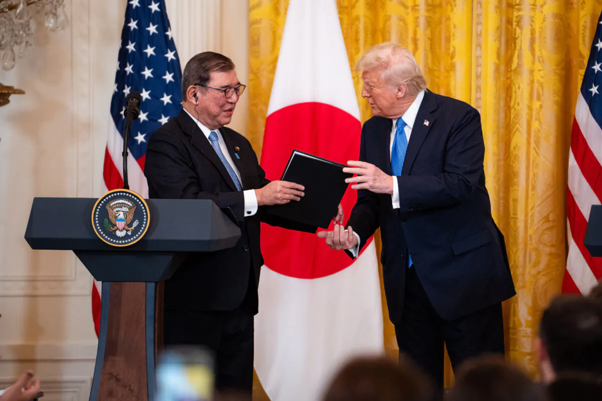 U.S. President Donald Trump holds a gift for Japanese Prime Minister Shigeru Ishiba during a press conference at the East Room of the White House in Washington on Feb. 7, 2025. (Madalina Vasiliu/The Epoch Times)