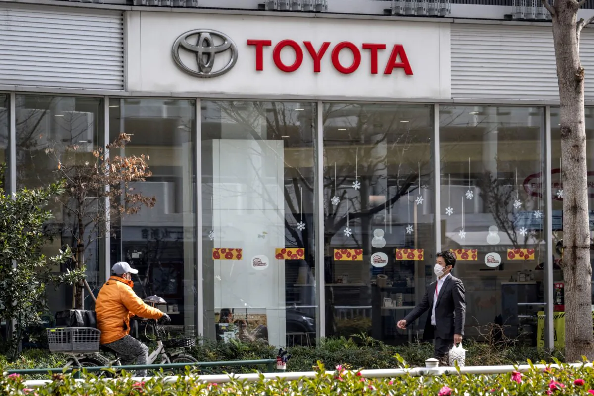Pedestrians walk past a car dealership for Japanese automaker Toyota in Tokyo on February 5, 2025. The Japanese automaker is expected to announce their third quarter earnings later in the day on February 5. (Yuichi YAMAZAKI / AFP)