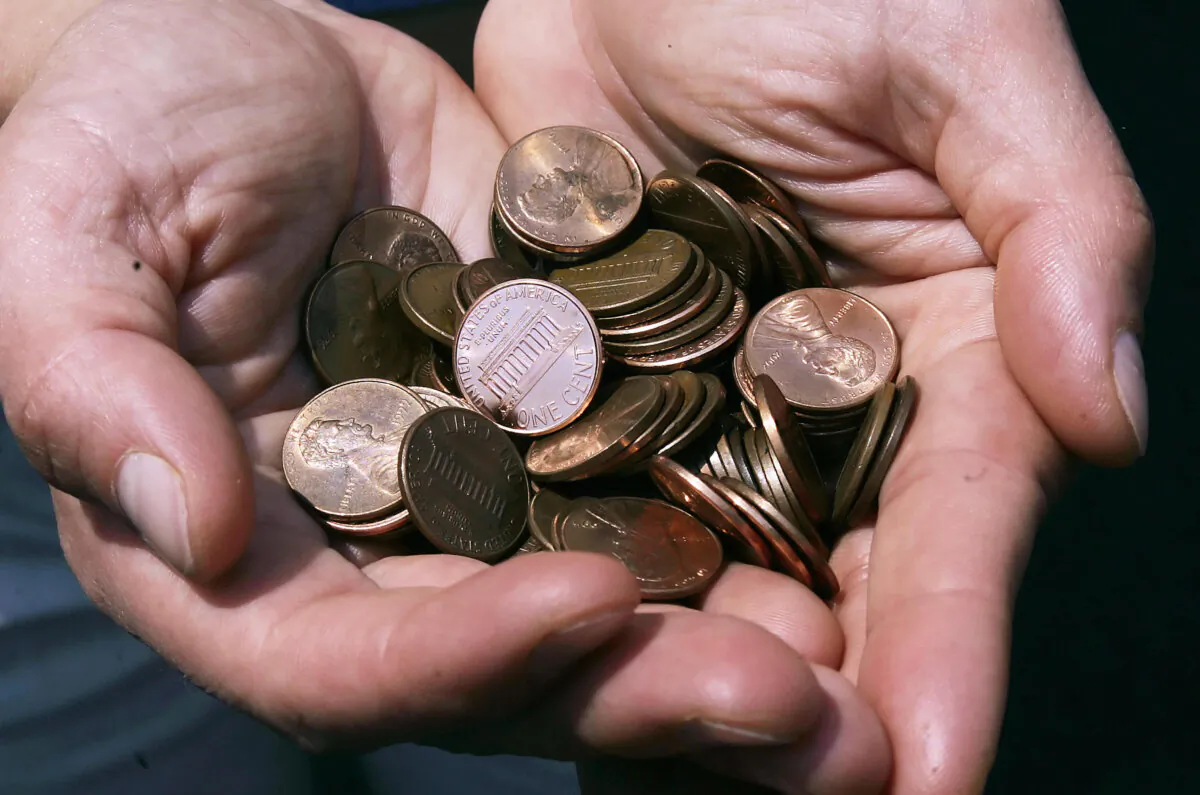 A man shows a handful of the U.S. cent in Washington on July 18, 2006. With the prices of zinc and copper going through the roof, the smallest American denomination is now worth more as a commodity than a currency. (Jim Watson/AFP via Getty Images)
