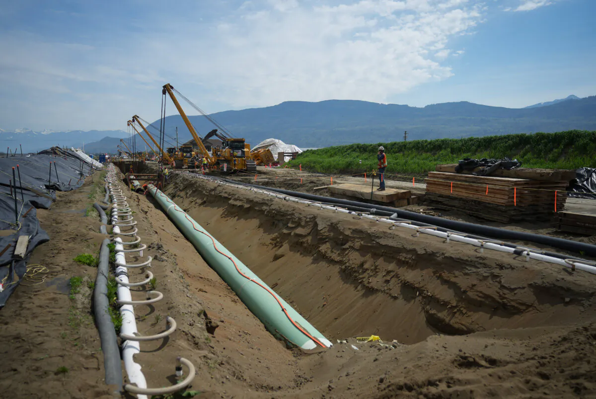 Workers position pipe during construction of the Trans Mountain pipeline expansion in Abbotsford, B.C., on May 3, 2023. (The Canadian Press/Darryl Dyck)