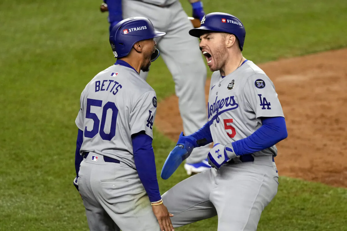 Los Angeles Dodgers' Mookie Betts (50) and Freddie Freeman (5) celebrate after scoring against the New York Yankees during the fifth inning in Game 5 of the baseball World Series in New York on Oct. 30, 2024. (Seth Wenig/AP Photo)